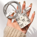 Bow Bliss Adapter Kit - coiled cable and bow-charm wall adapter in hand